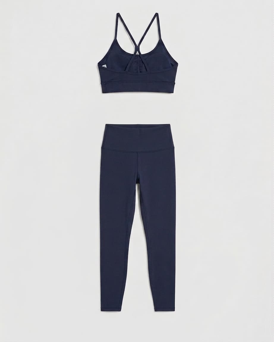 Navy sports bra and high-waisted leggings arranged as a catalog product image